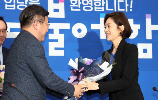 고민정(오른쪽) 전 대변인이 2일 서울 여의도 국회에서 열린 민주당 입당 기자회견에서 윤호중 사무총장으로부터 축하 꽃다발을 받고 있다. 연합뉴스